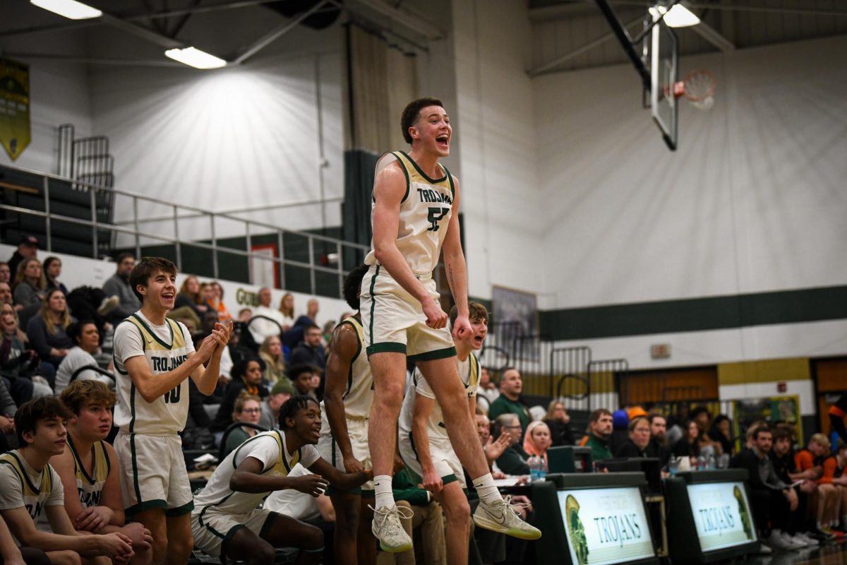 Springing from the bench, Jack McCaffery '25 celebrates a teammate scoring Jan. 17.