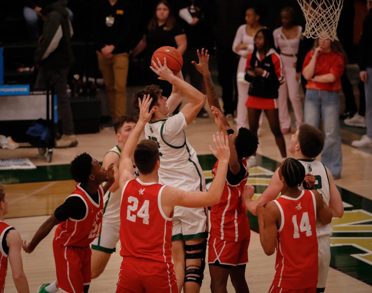 Mason Goering '26  jumps up to take a shot while players from City attempt to block it on Dec. 20.