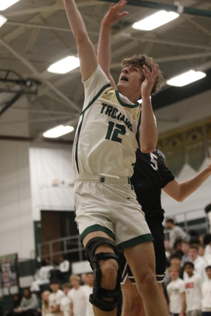 Mason Goering '26 pushes past Liberty's defense to go for a layup. He ended the game with 14 points, 5 rebounds and 4 assists, Goering made 3 points more than his game average.
