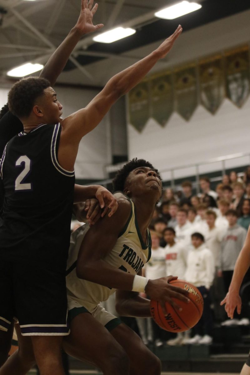 Julian (JuJu) Manson '26 attempts to score a lay up over the defender. Manson had more than double his average 11.3 points per game, scoring 25 points.
