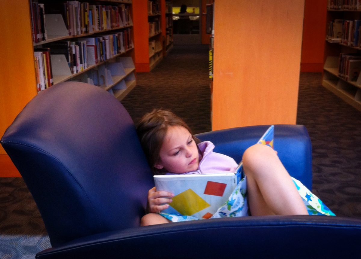 Marie Stier '25 reading in the library as a child.