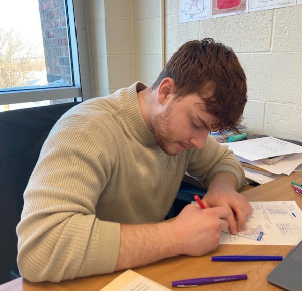 Gabriel Elsden grades math tests after school.