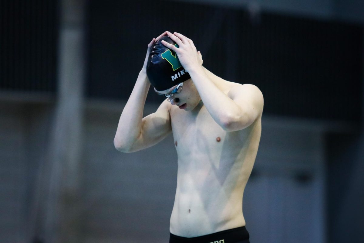 Oliver Mikulski '26 adjusts his cap, preparing himself before diving. 