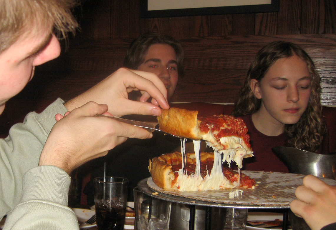 Colin Wehrle '27 picks up a slice of deep dish pizza. 