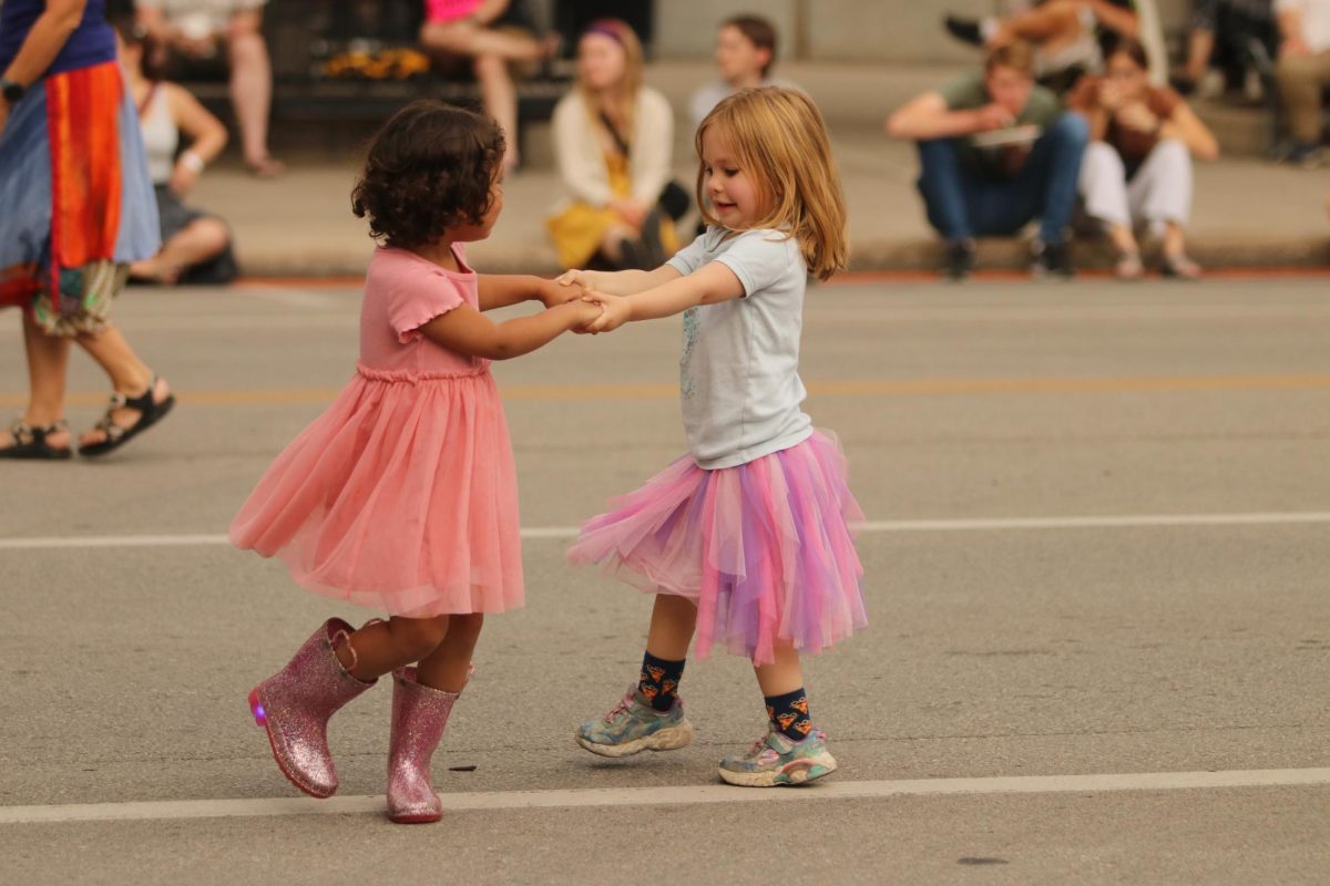 Two girls dance hand in hand at the live music show during Iowa City's annual Jazz Festival on July 6.