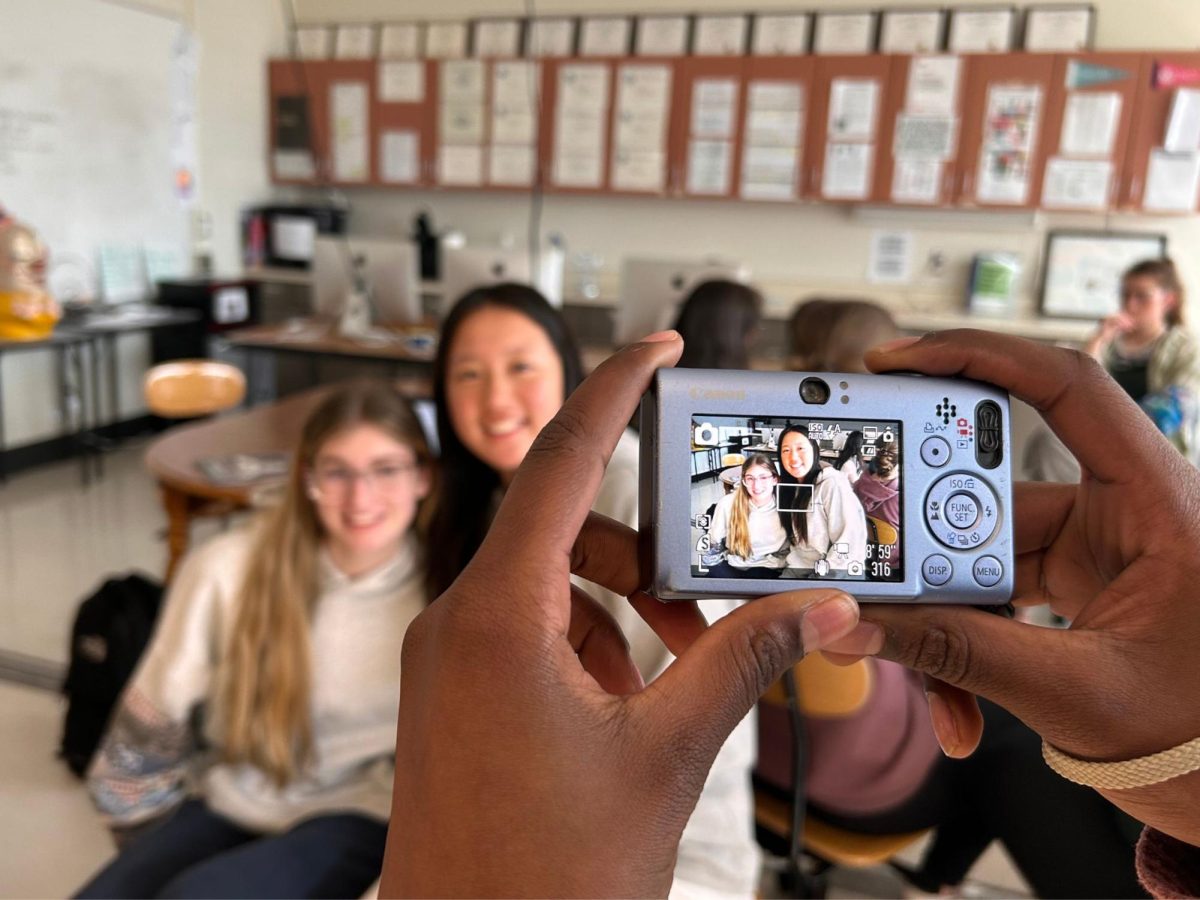 Lila Eastvold '27 and Gianna Liu '25 get their picture taken using a digital camera