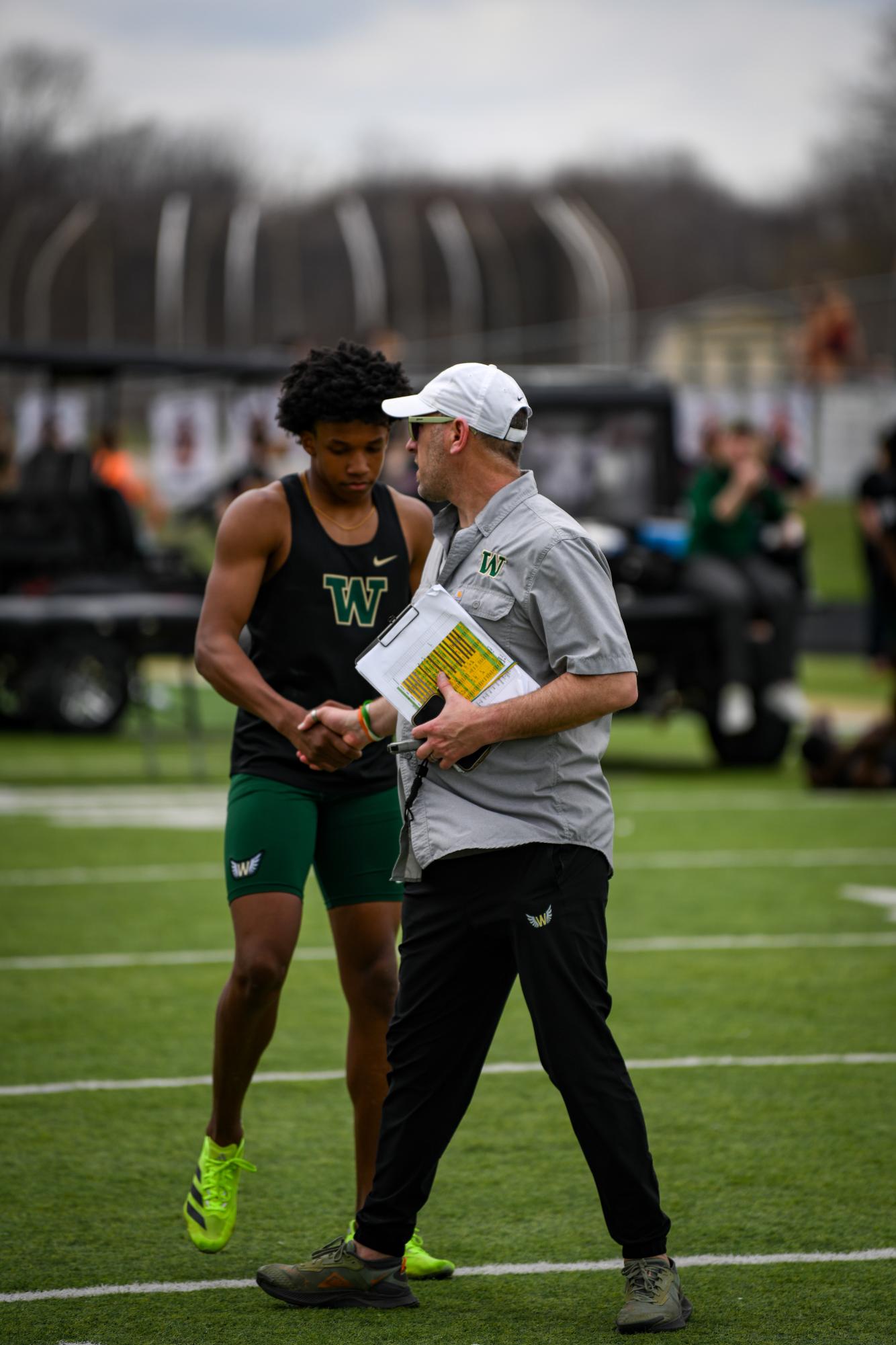 Coach Travis Craig congratulates Neil James '27 after his race during the Hollingsworth Relays March 29.