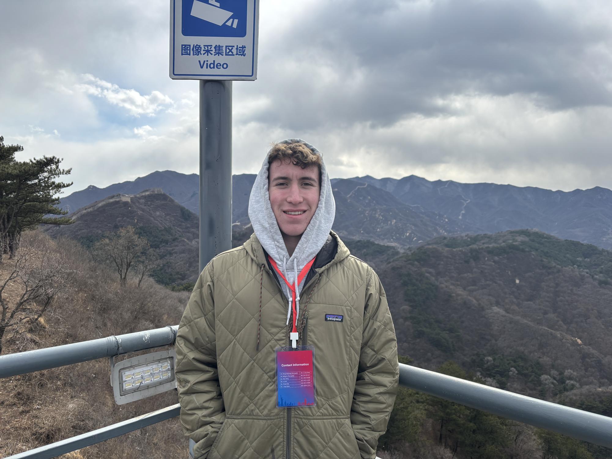 Kellen Craig '26 stands on the Great Wall in Shijiazhuang, China and smiles for a picture after climbing a small bit of the 13,171 mille long wall.