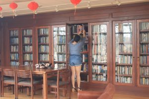 Current Iowa Writers Workshop Christine Kim '26 looks for a book in the Dey House.