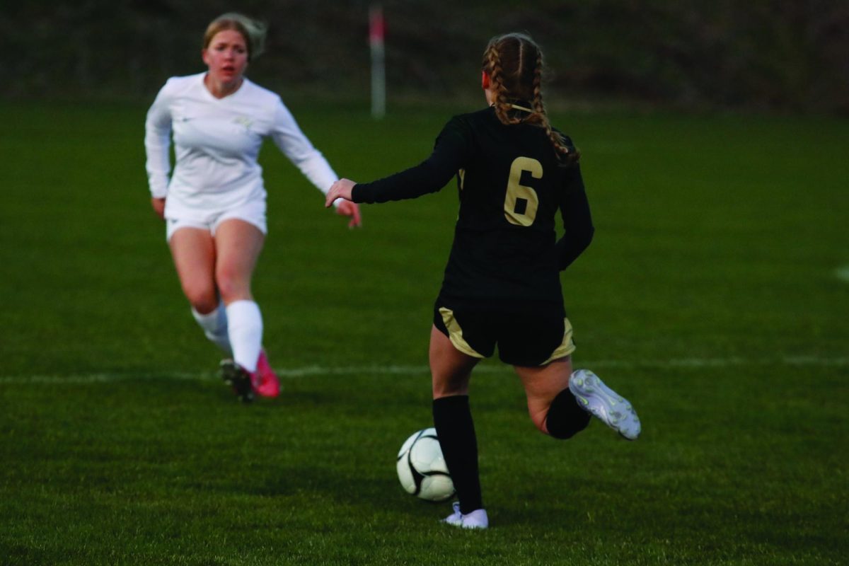 On the West High field, Sophia Oulman ‘25 kicks the ball away from her opponent March 31.