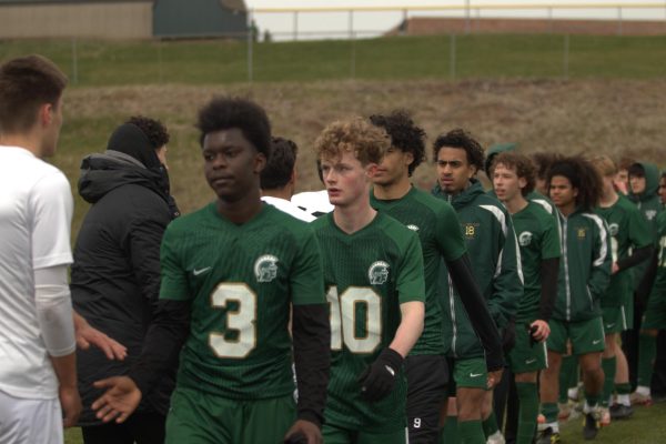 Daniel Fuentes '25 shakes the hands of Des Moines Valley players on April 4. 