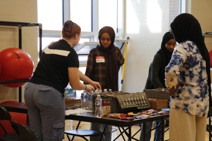 Volunteers Charlotte Stephens '26 and Sajdah Mahmoud '28 organize and hand out snacks for donors to recuperate after their appointment. 