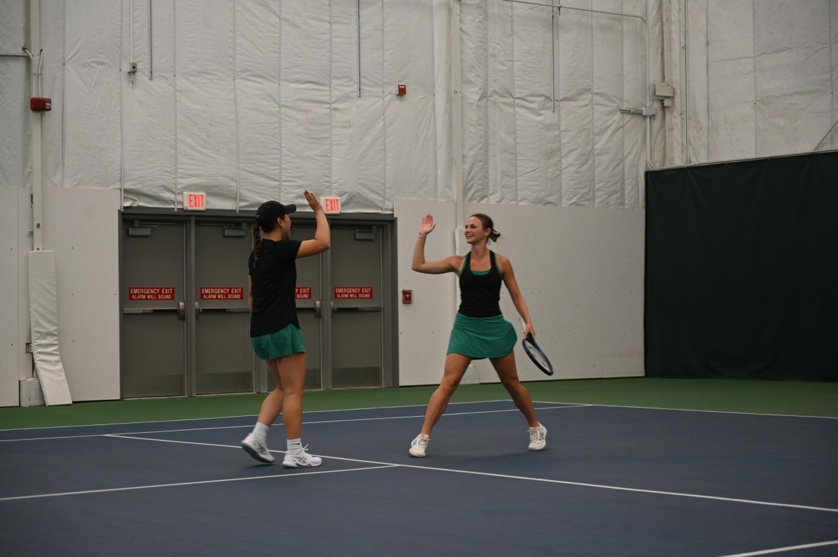 Seniors Claire Hahn and Marie Stier high-five after winning the first point of 1 Doubles against Dubuque Hempstead May 20. 