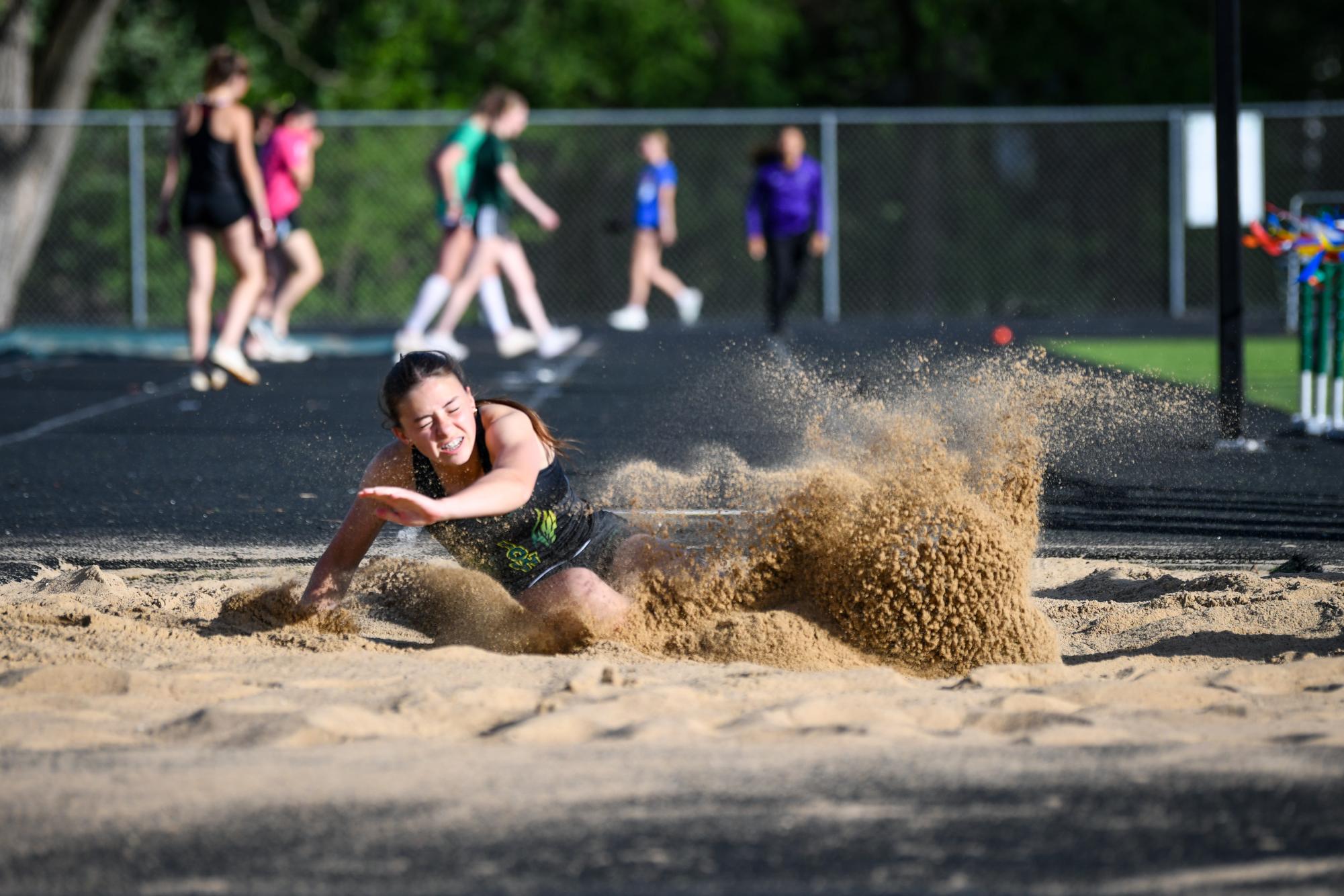Landing in the sand, Amara MacLagan ’28 competes in the long jump at the state qualifying meet May 15, where she placed first with a jump of 18-01.75.