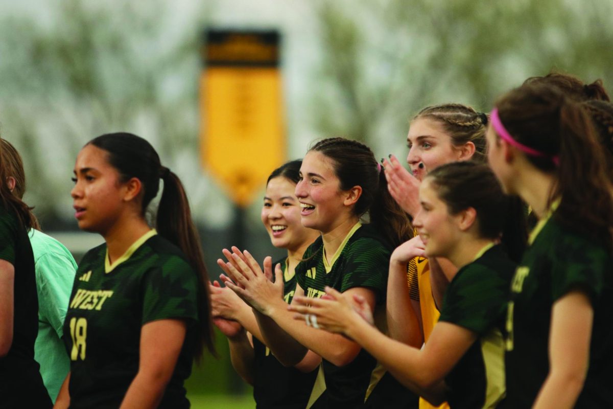 The girls' soccer team celebrates a goal.