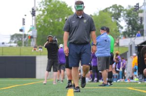 Soccer head coach Brad Stiles walks with his head down while he mentally prepares for a game against West's crosstown rival, the Little Hawks.