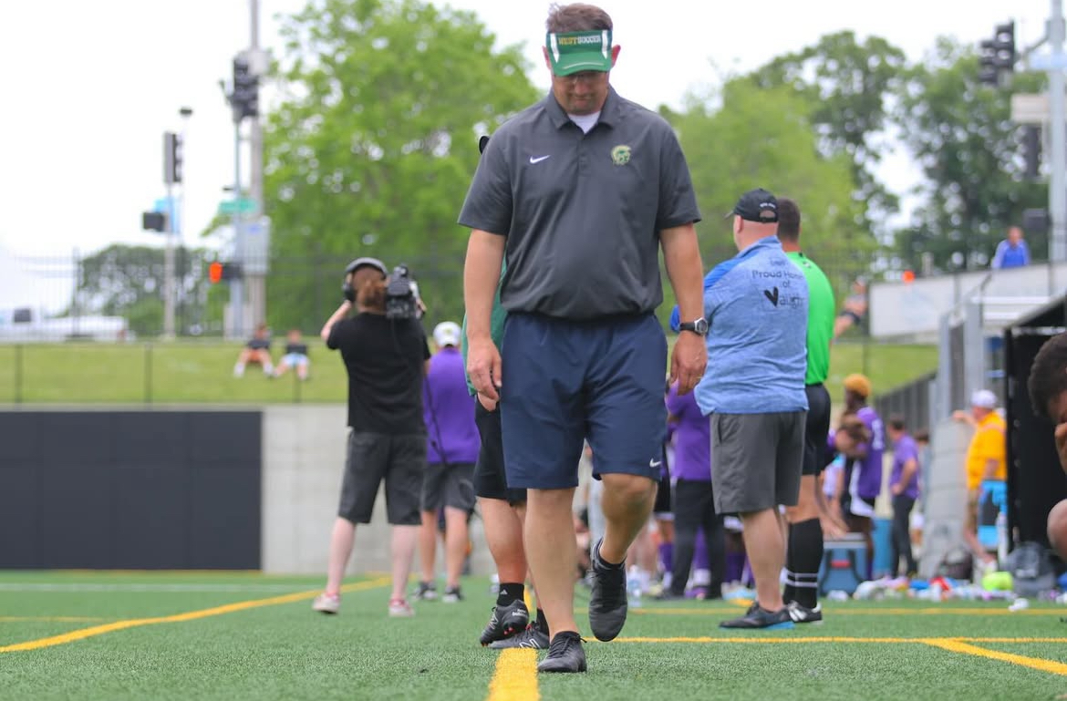Soccer head coach Brad Stiles walks with his head down while he mentally prepares for a game against West's crosstown rival, the Little Hawks.