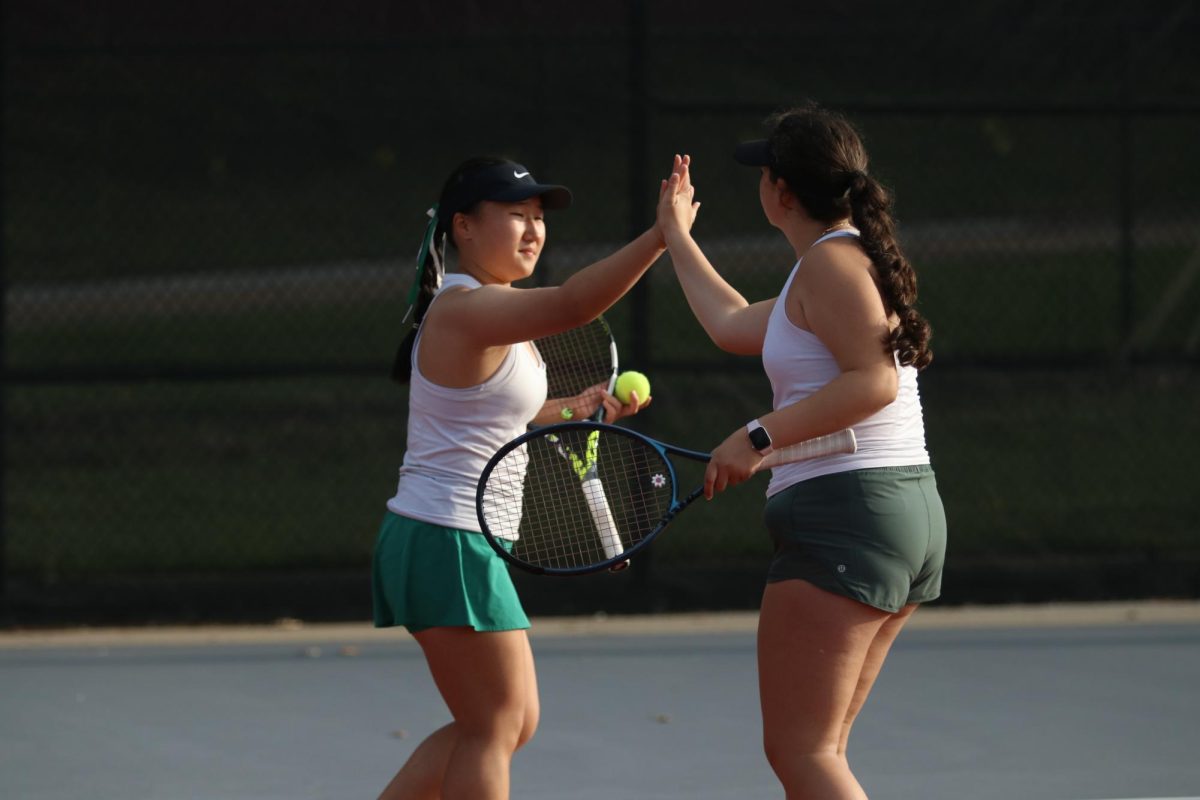 Grace Wang '27 high fives Iris Vasi '28 after winning a point against City High in 2 Doubles on May 1.