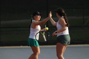 Grace Wang '27 high fives Iris Vasi '28 after winning a point against City High in 2 Doubles on May 1.