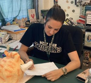 Traci Burns grades tests after school.