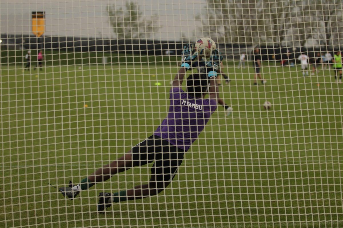 Goalie Chris Mayambu '26 blocks a shot from his teammate during warmups.