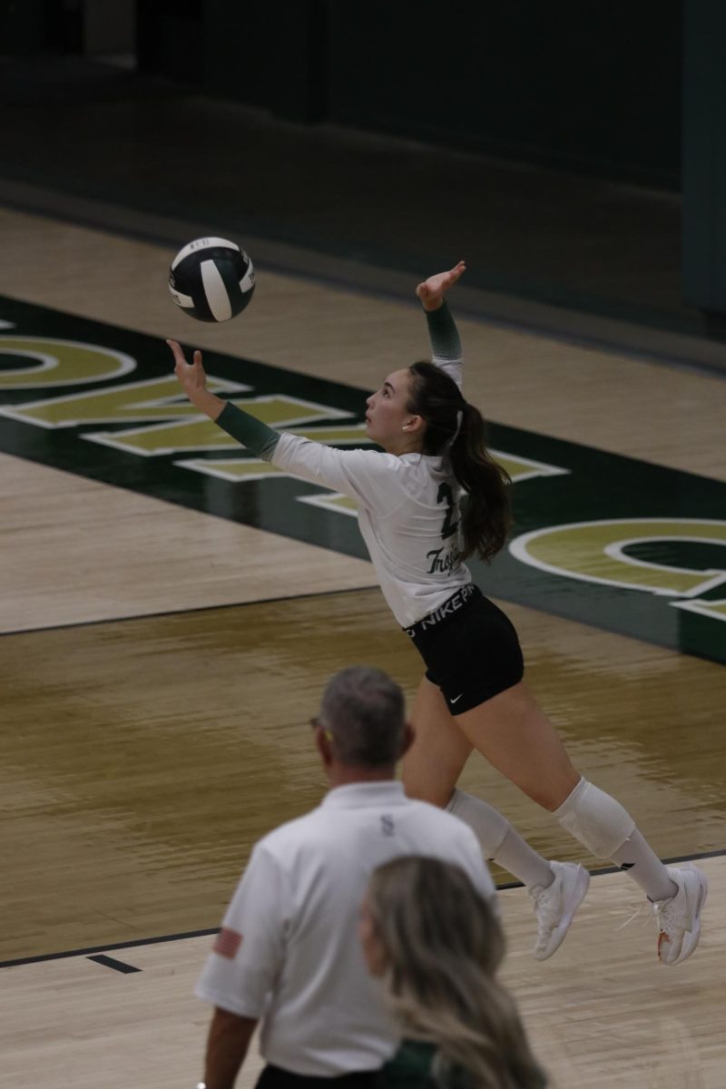 Libero Izzie McDonald '28 tosses the ball for a jump serve.