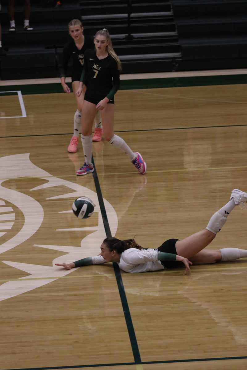 Libero Izzie McDonald '28 dives to get the ball up.
