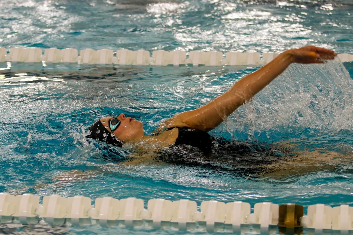  Ella Lewis '28 swims backstroke at the meet.