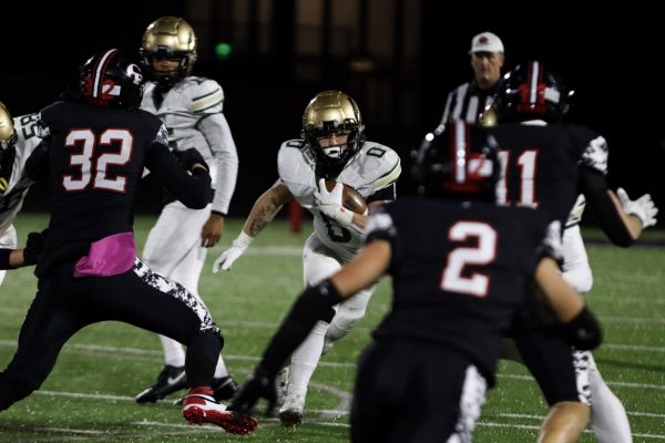 After receiving the ball Campbell Janis '26 breaks through Cedar Falls players attempting to score for the Trojans.