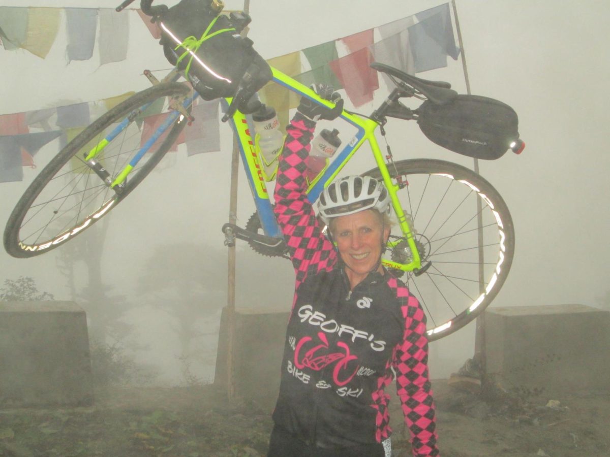 Stierler poses victoriously at the top of a peak in Bhutan, where she went bike touring.