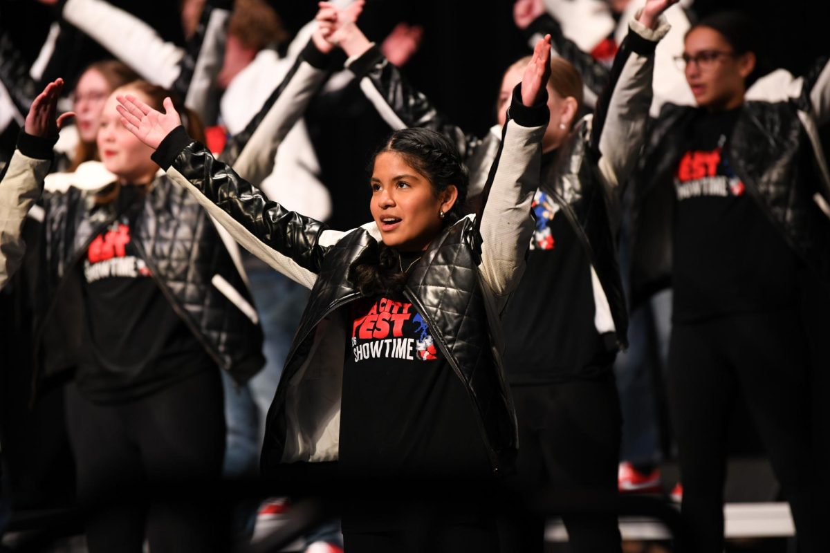 Lifting her arms, Luisa Nicolas '28 performs with Showtime. Showtime performed their show "Level Up" in Arganbright Auditorium for the annual Winter Swing Show Dec. 14.