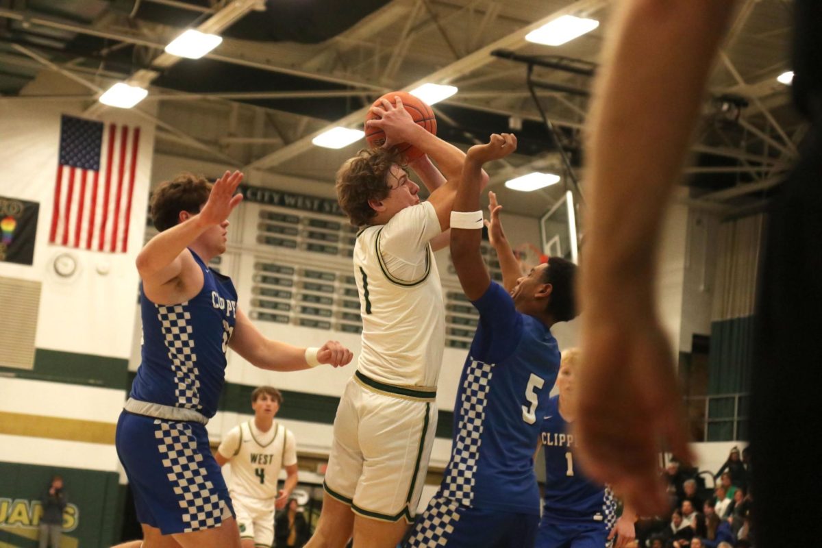 Ethan Headings '26 goes up for a layup while being guarded by two CCA players