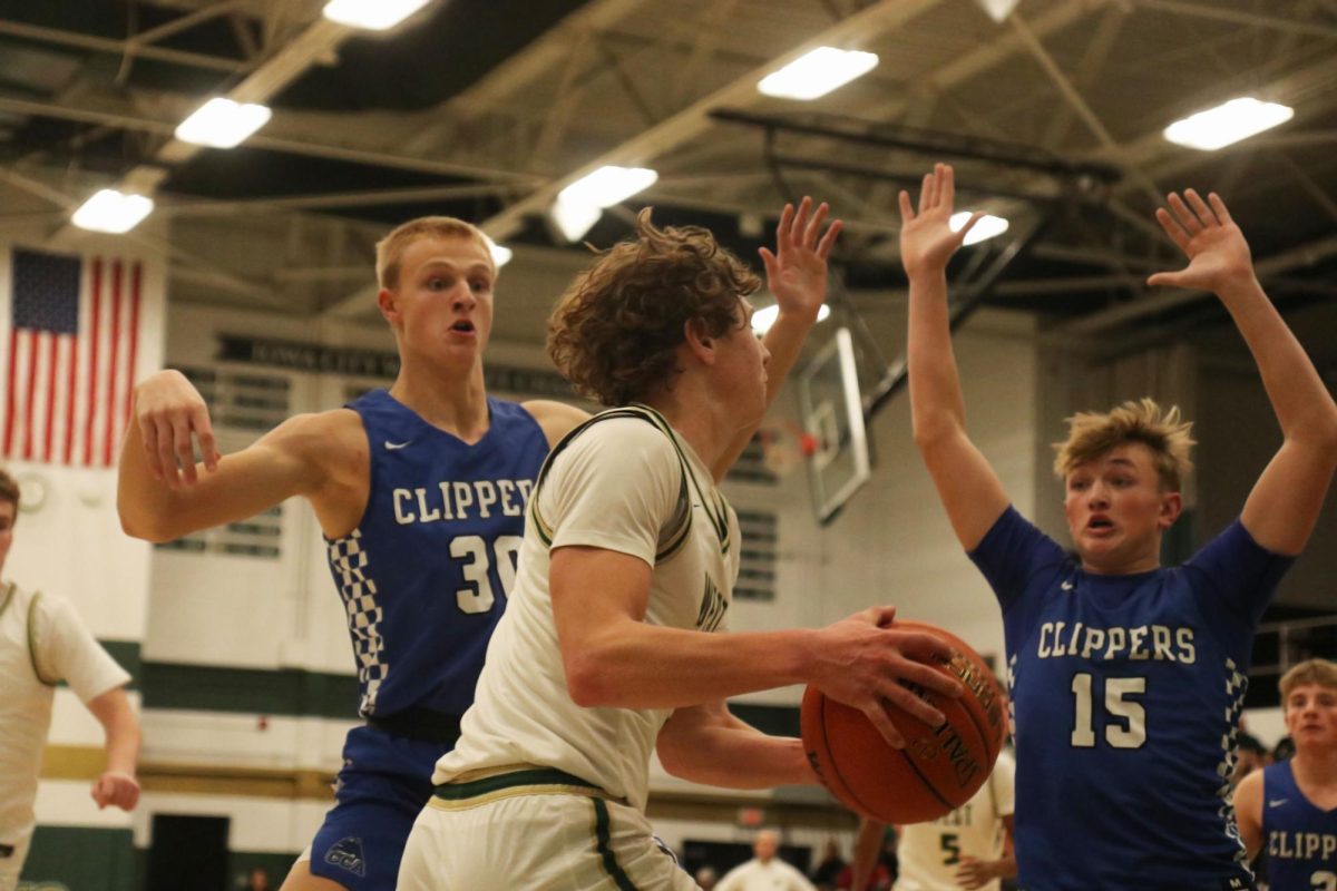 Ethan Headings '26 Looks to pass the ball as he is guarded by two CCA players