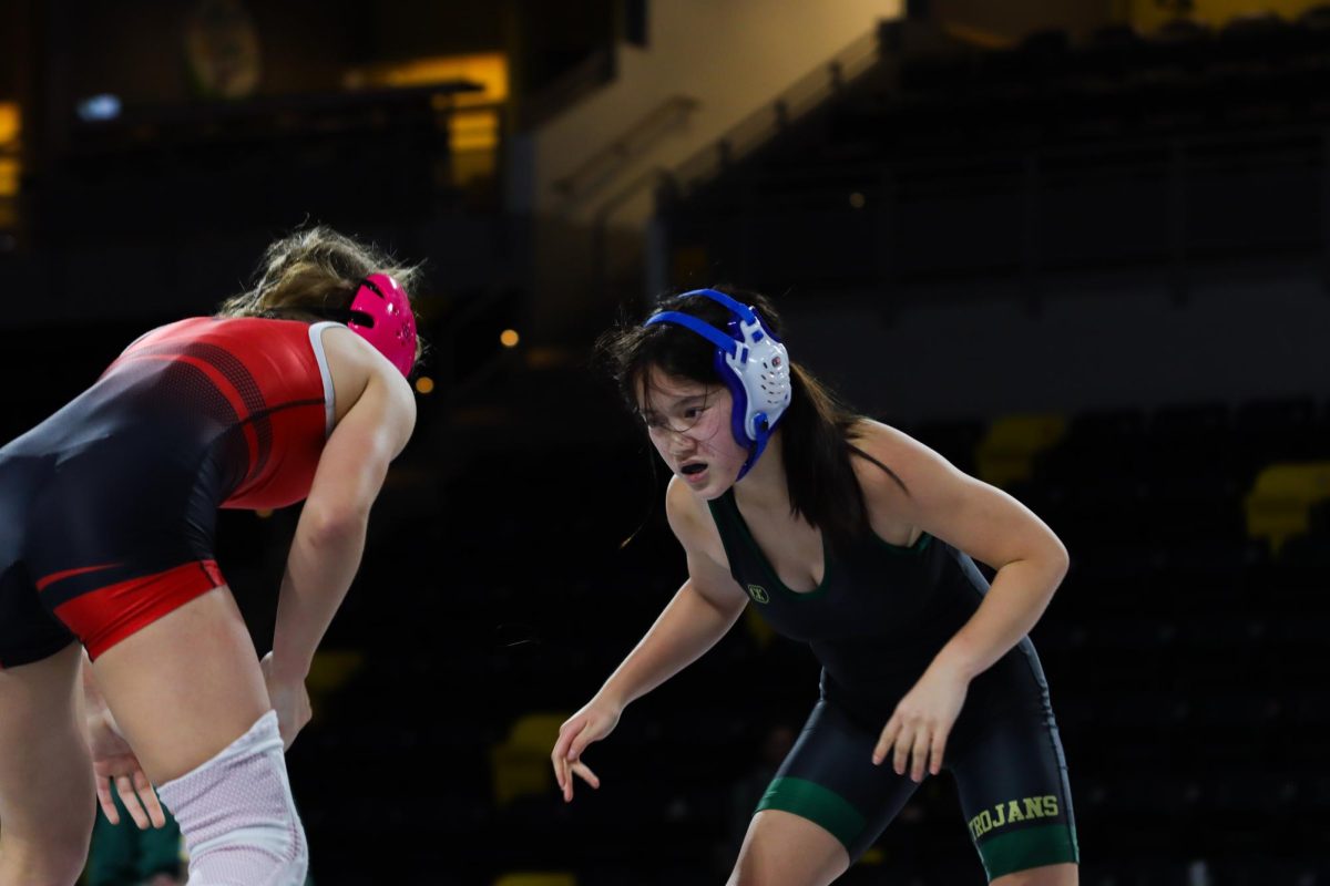 Planning her next move, Angela Wang ‘29 gears up to wrestle her opponent from City High Dec. 18. Wang lost by fall in two minutes and 11 seconds.