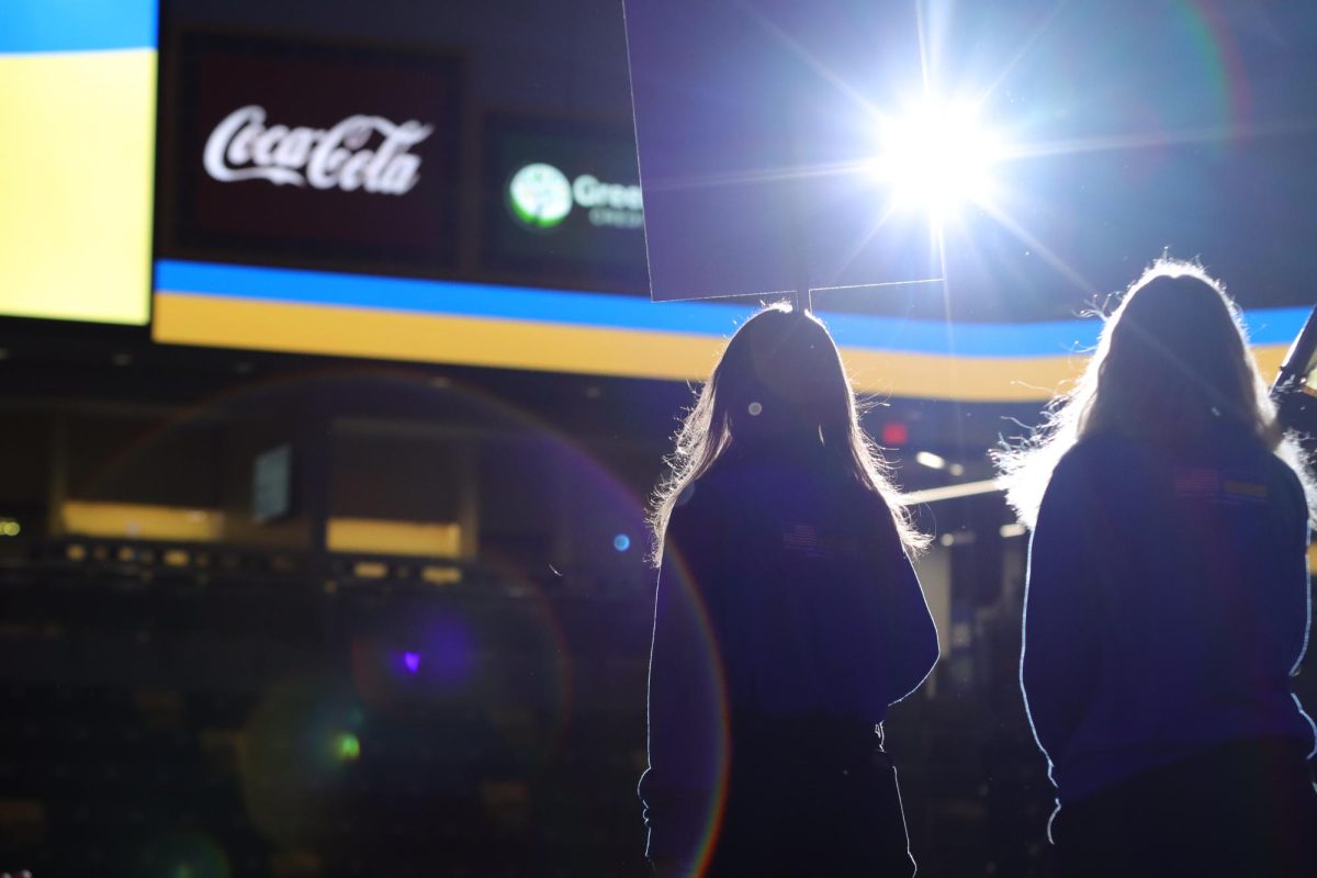 Carrying a flag and a sign, two girls lead the Ukrainian national team onto the mat before the meet. Before the teams wrestled each other, they stood for both countries’ national anthems and exchanged gifts.