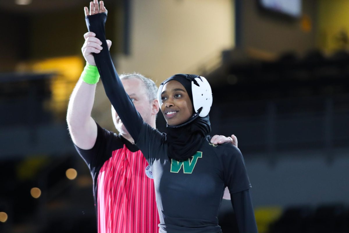 Accepting the forfeit at 100 points, the referee raises senior Minna Abdalla’s hand to declare her the winner. The event at Xtreme Arena Dec. 18 was Abdalla’s first competition as a part of the Trojan’s girls wrestling team after she joined the team partway through the season.