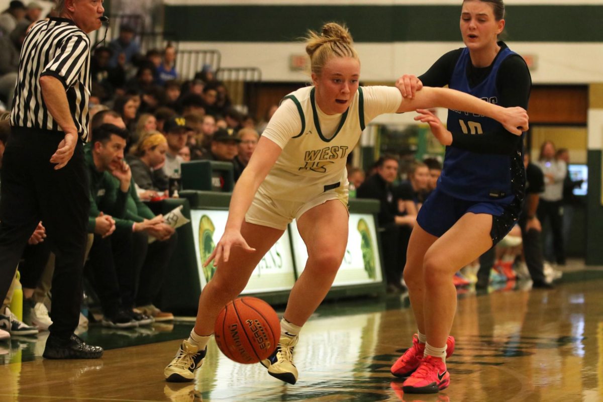 Grace Fincham '26 Dribbles around a CCA defender trying to get the basket