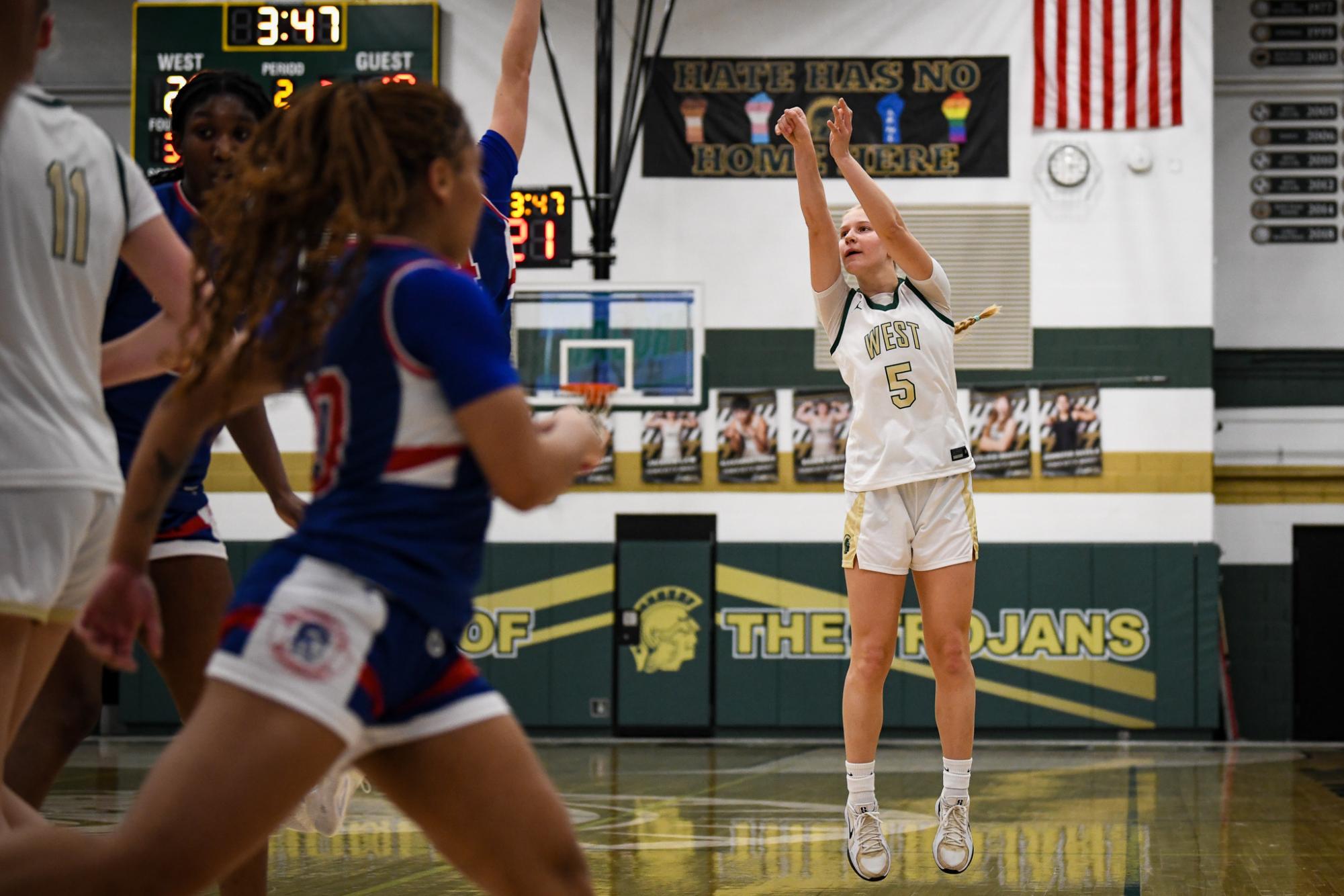 Taking a shot, Kate Van Waning scores from the three-point line. Van Waning helped give the Trojans a 14-6 lead over the Warriors during the first quarter in the north gym Jan. 3. 