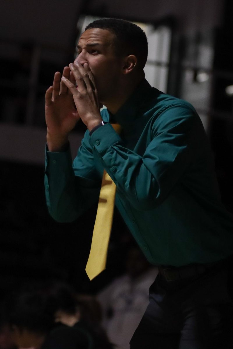 Coach Matt Betchel cheers on his team from the sidelines during sophomore Josie Clark's match.