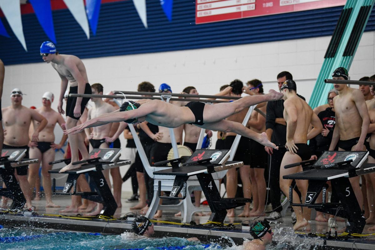 Diving into the water, Alex Rouwenhorst '27 competes in the 100Y Fly at Mercer Aquatic Center Dec. 20. Rouwenshorst placed sixth in the 100Y Fly with a time of 57.75 in the Little Hawk Invite.