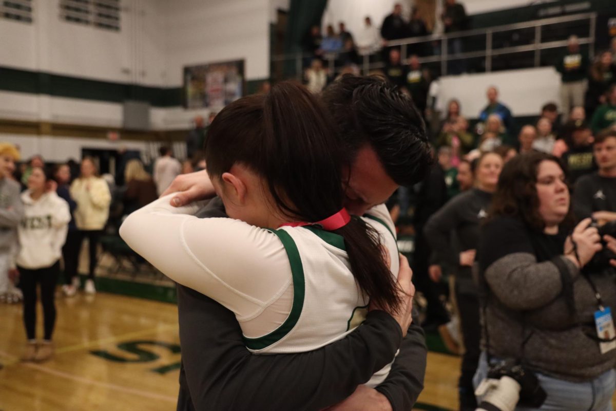 Head Coach Nate Frese and his daughter Ava Frese '26 embrace after winning the game. "[quote from a frese]" 