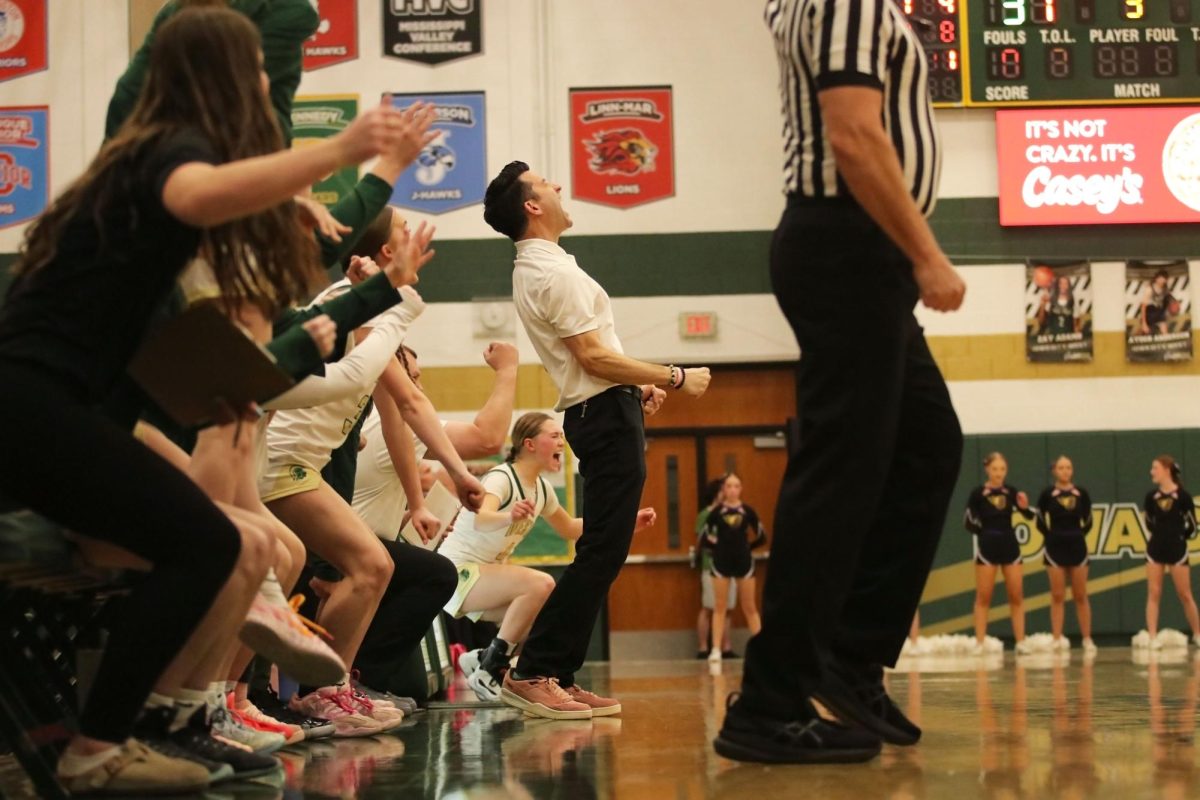 Iowa City West High varsity girls basketball Head Coach Nate Frese erupts in cheers with the West High bench and student section following a buzzer-beating three-point shot from Frese's daughter, Ava Frese '26. The shot came just prior to half time to tie the match 29-29 against first-ranked team in Iowa, Johnston High School, in a regular season match at Iowa City West High School Feb. 16, 2026.