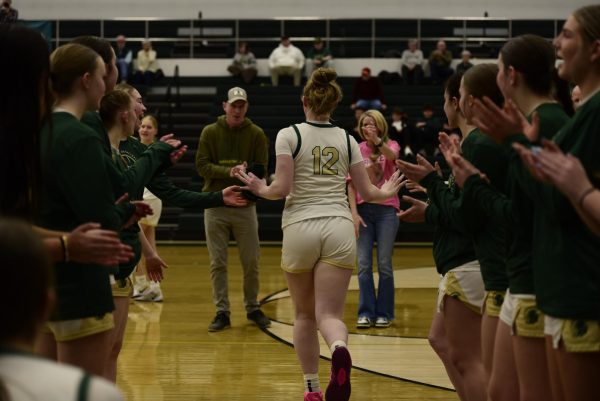 Grace Fincham '26 runs out, receiving high fives and encouragement from teammates and coaches prior to the game held Feb. 13. 