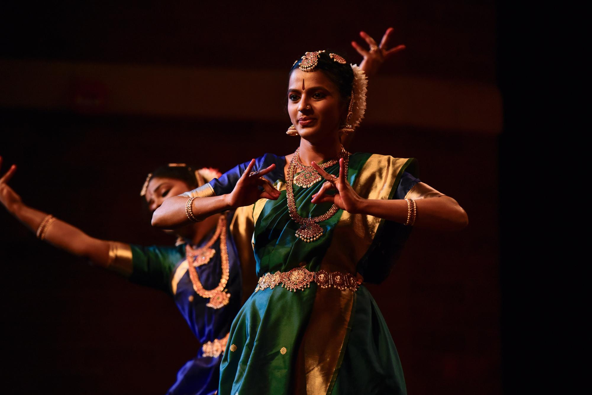 Dancers Amrutha Akula, Keerthana Ramkumar and Thaneesha Puviarasan perform a traditional Bharatanatyam dance, rotating as the plot advances, with two dancers staying in the common resting position. 