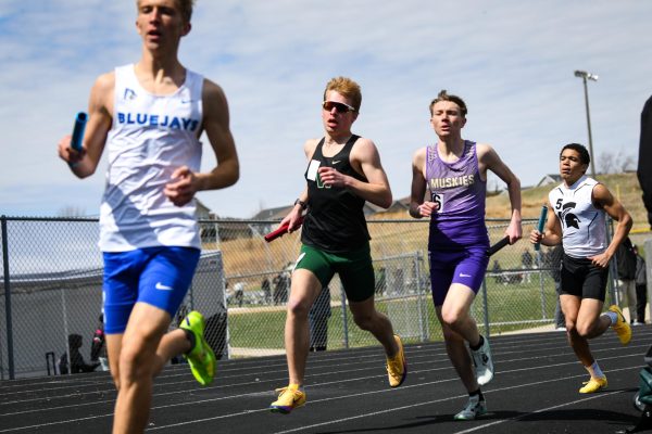 Turning onto the backstretch, Jake Weiler '28 anchors the Distance Medley Relay at Trojan Field March 28. The quartet finished third with a time of 3:56.38. 