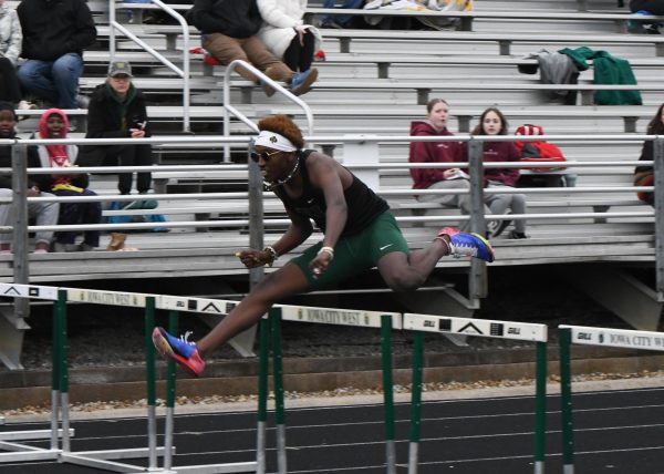 Bounding over a hurdle, Waleed Ibrahim '26 competes in the 110m Shuttle Hurdle Relay at Trojan Field April 11. The quartet placed first with a blue standard of 57.21, setting a new school record.