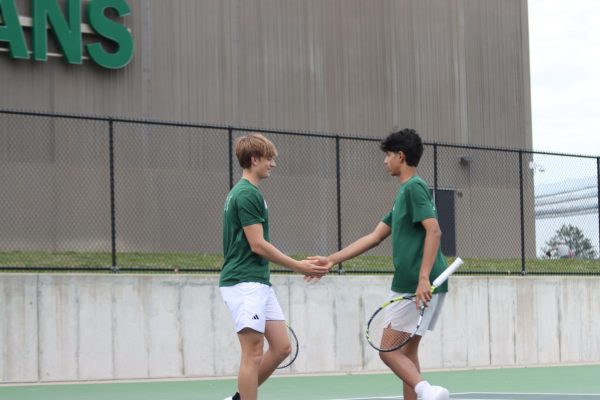 Aryan Harwani '29 and Pierce Hribar '28 high five after a rally at the West High tennis courts April 28. 