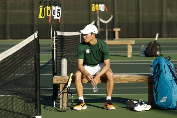 Aaron Kang ’27 rests between matches at the West High tennis courts April 16. Kang later defeated Prairie's Brodie Cotts 6-0, 6-0.