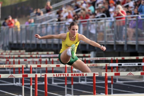 Bounding over a hurdle, Savannah Graham '29 races the 100-meter shuttle hurdle relay at Iowa City High School May 14. The quartet placed third with a time of 1:09.85.
