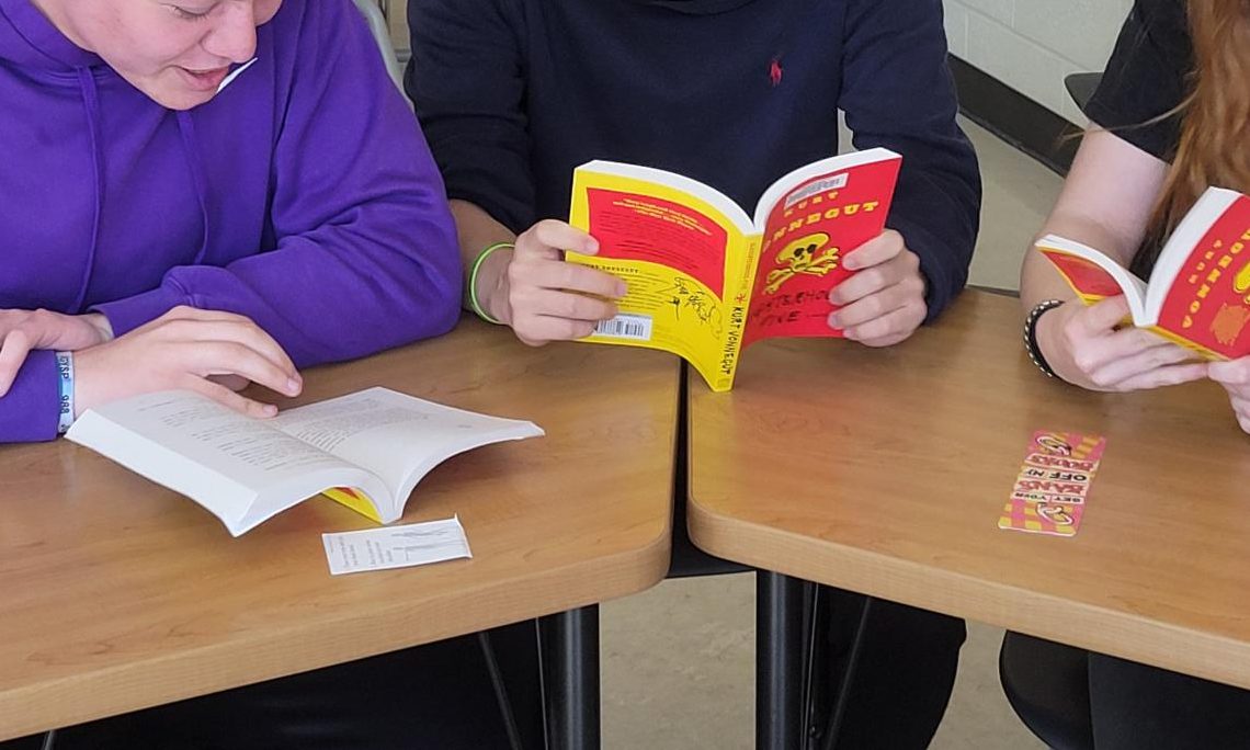 Three members of the West High Banned Book Club read together in room 108 May 13. The club is currently reading “Slaughterhouse Five” by Kurt Vonnegut.